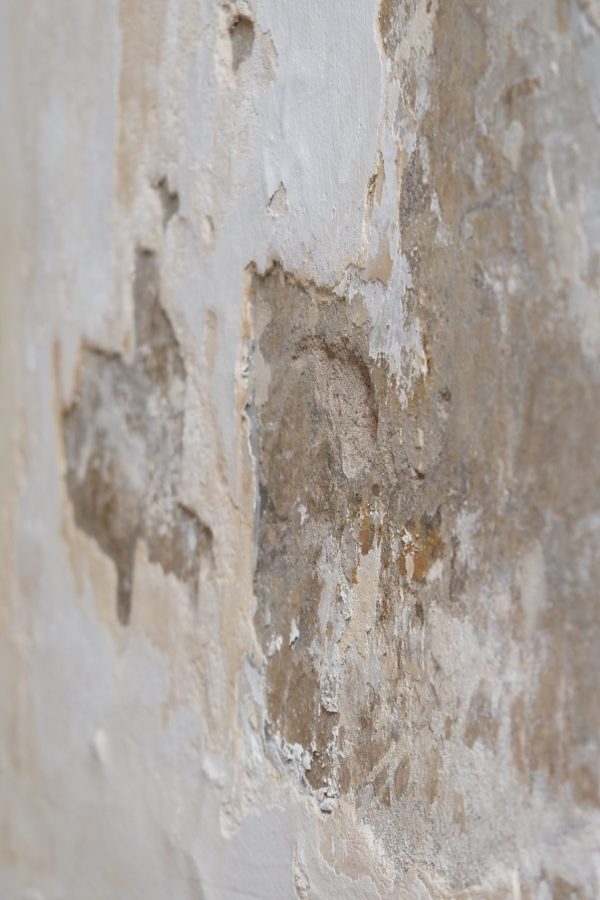 The wall shows extensive peeling paint and damage near the corner.